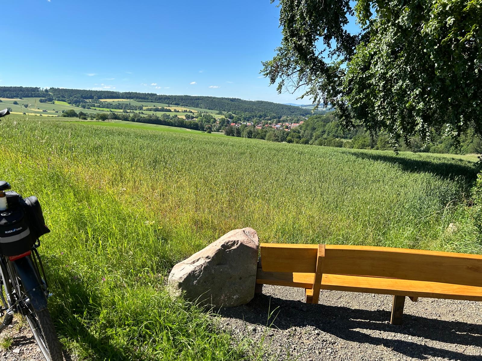 Bank mit Aussicht über Kornfelder und Wald