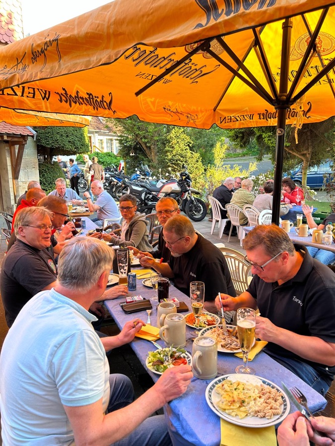 Biker beim Essen unter den Sonnenschirmen