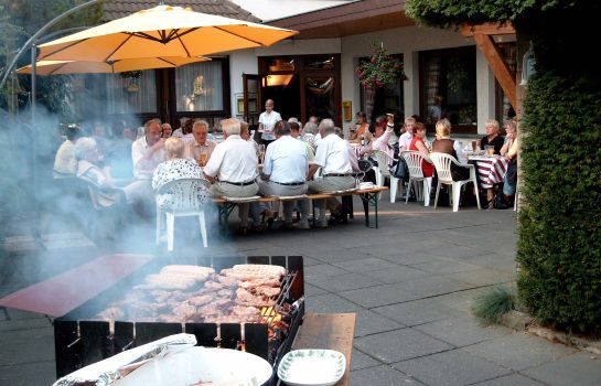 Grillabend mit Gästen an langen Tischen auf der Terrasse