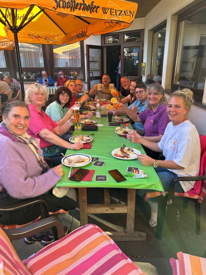 Lange Tischrunde beim Essen auf der Terrasse